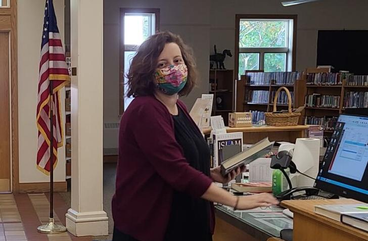 Ksana Broadwell, director of the Ulysses Philomathic Library, gathers books at the front desk of the library. The library has new Friday grab-and-go hours: 1 to 4 p.m. Come Friday to pick up your holds or browse the patio windows for something to read or watch over the weekend. The new hours do not replace the Tech Cart hours, which remain the same for all patrons’ printing, copying, faxing and scanning needs.